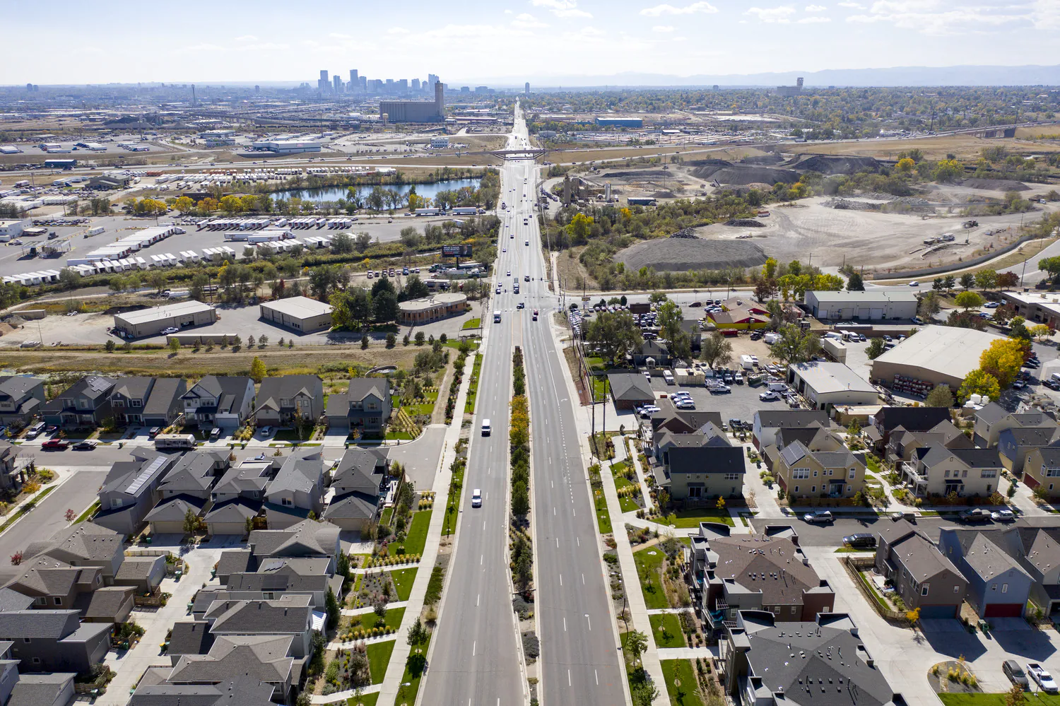 Aerial view of Pecos Street extending towards a distant city skyline, with residential neighborhoods and commercial areas on either side.